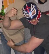 Hombre con máscara de luchador mexicano flexiona los músculos de sus brazos